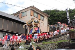 蛭子神社夏祭り写真②-大人屋台自治会提供 - 【公式】兵庫県たつの市の観光サイト - 【公式】兵庫県たつの市の観光サイト A crowd in colorful festival outfits carries a large ornate float down stone steps during a traditional Japanese matsuri.